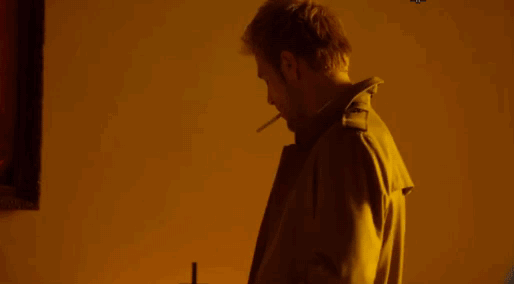 constantine lighting up cigarette in a candle